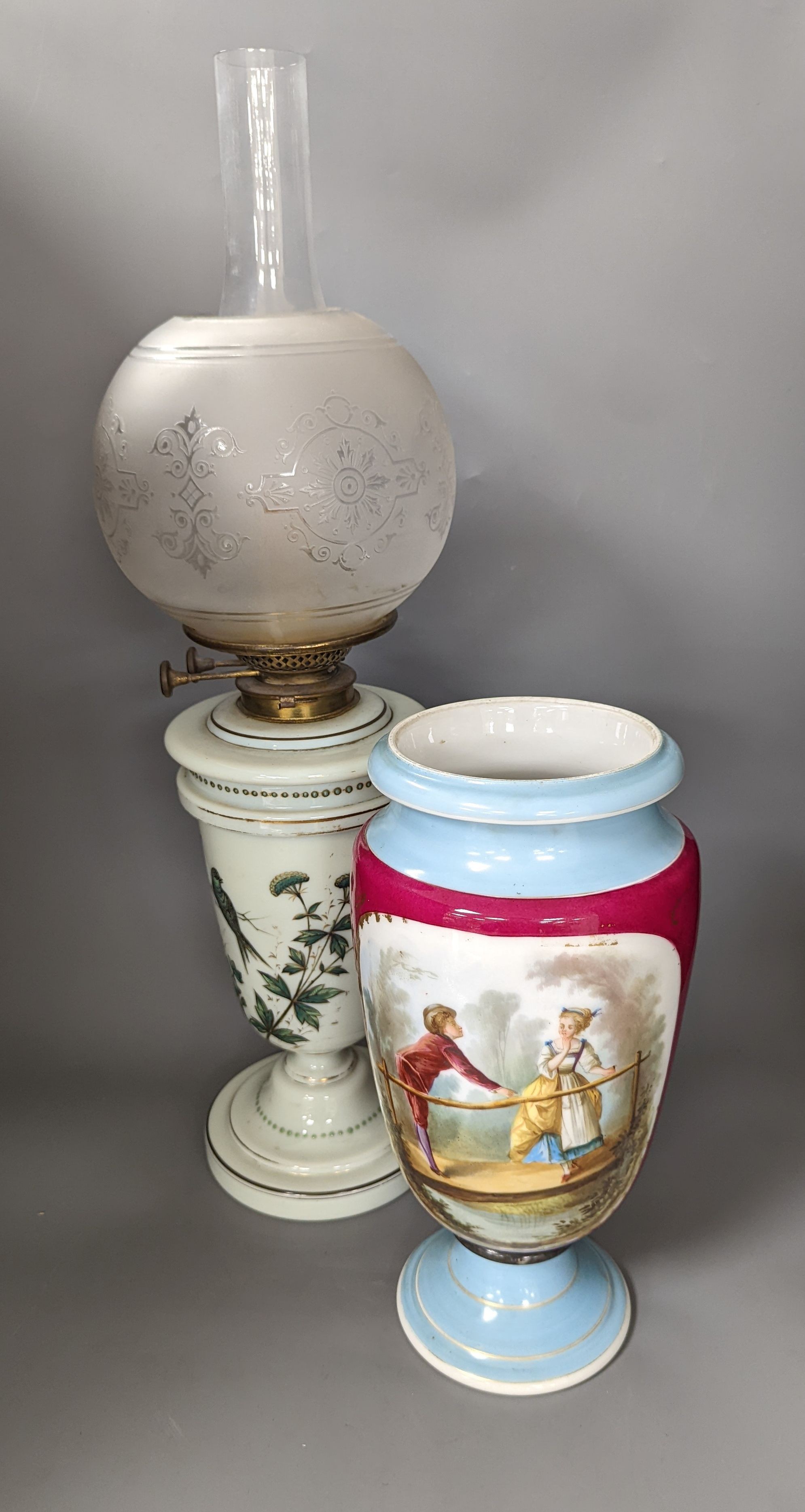 A late 19th century French enamelled green glass oil lamp and glass shade and a Paris porcelain vase, Oil lamp 61 cms high.